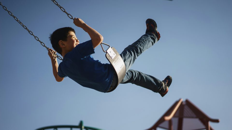 Child playing on playground slide at L'Abri Apartments